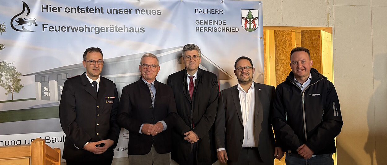 Fünf Personen vor einem Plakat